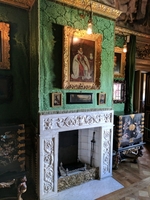 A view of a wall in the Green closet at Ham House, including the fireplace, several paintings, 2 cabinets and the green wall hangings (© Isaksenk, CC BY-SA 4.0)