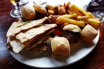 The sharing plate, with three mini lamb burgers, three mini beef burgers, flatbread and hummus (as well as cucumber and pepper sticks), calamari and chips. Good for sharing. At The Crown and Greyhound, Dulwich Village. (© Ewan Munro, CC BY-SA 2.0)
