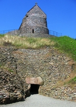 Restored entrance to Neolithic tomb, mediaeval chapel on mound, La Hougue Bie, Jersey